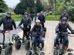 A group of travelers wearing helmets on e-Rider vehicles in a park in Budapest