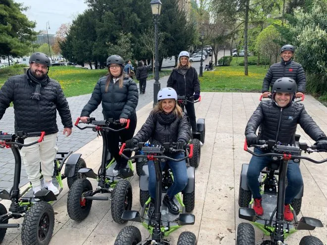 A group of travelers wearing helmets on EZRaider vehicles in a park in Budapest